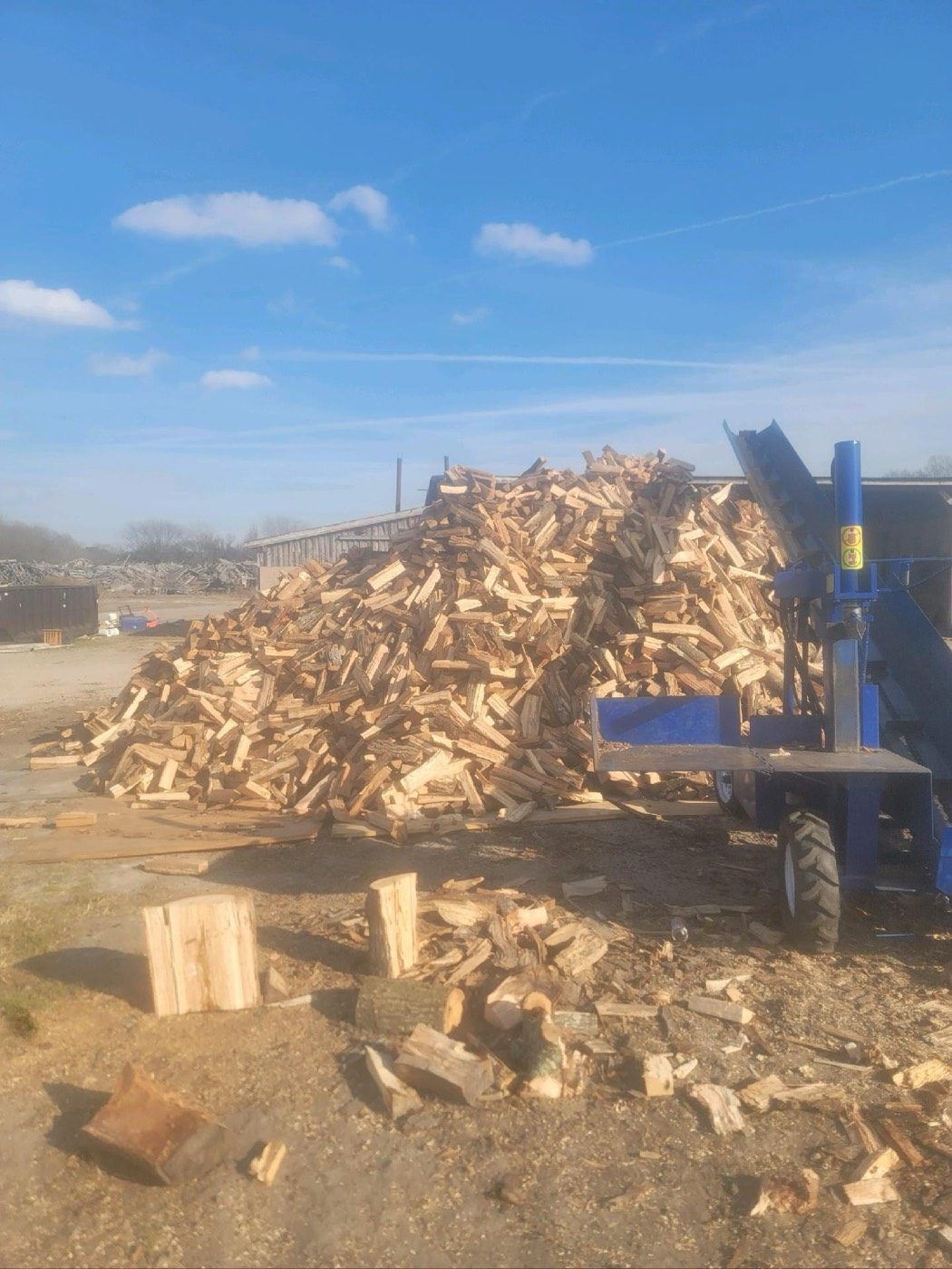 Freshly split firewood beside the Tree Works firewood processor